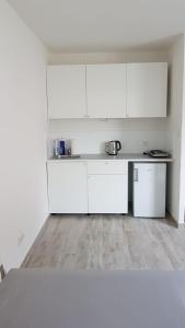 维也纳Excellent Apartment M&L的白色的厨房配有白色橱柜和木地板