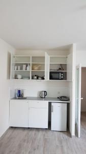 维也纳Excellent Apartment M&L的一间白色的厨房,里面配有白色的橱柜