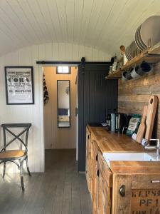 基德灵顿Shepherds Huts的厨房配有柜台、桌子和椅子
