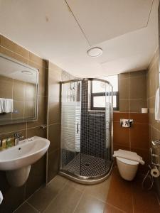 安曼切利诺公寓式酒店的带淋浴、盥洗盆和卫生间的浴室