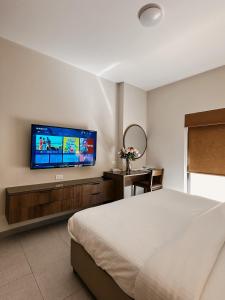 安曼切利诺公寓式酒店的一间卧室配有一张床和一台平面电视