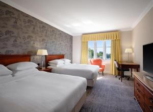 德比Delta Hotels by Marriott Breadsall Priory Country Club的酒店客房设有两张床和一台平面电视。