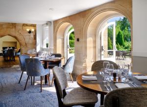 德比Delta Hotels by Marriott Breadsall Priory Country Club的一间带桌椅的餐厅和一个拱门