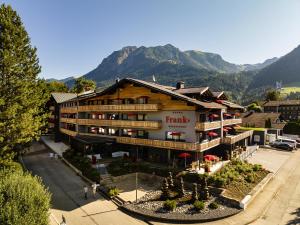 奥伯斯特多夫Hotel Franks的一座以山峰为背景的大型酒店