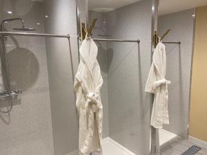 麦克尔斯菲尔德Hollin House Hotel的玻璃门上的淋浴和白色毛巾