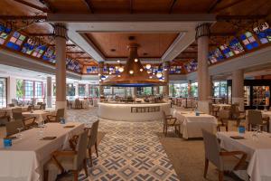 莫甘海滩莫甘海滩热忱度假酒店的餐厅配有白色的桌椅和吊灯
