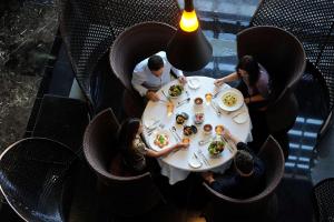 阿布扎比Southern Sun Abu Dhabi的一群坐在桌子旁吃食物的人