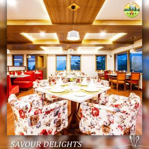 马拉里Anand Vardhan Resorts的一间带桌椅和窗户的用餐室