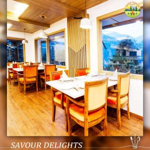 马拉里Anand Vardhan Resorts的用餐室设有桌椅和窗户。