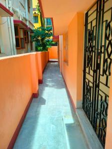 加尔各答Kanan Villa的一条小巷,拥有橙色的墙壁和走廊