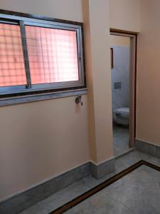 加尔各答Kanan Villa的一间空浴室,内设窗户和卫生间