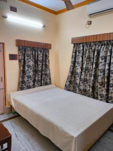 加尔各答Kanan Villa的一间卧室设有一张床和两个窗户。