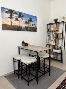萨尔布吕肯Zentrale gemütliche Wohnung的棕榈树间里的一张桌子和凳子