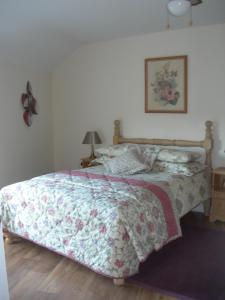 Campsey坦普尔莫伊尔农场度假屋的一间卧室配有一张带花卉棉被的床