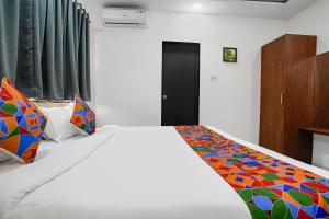 纳威孟买FabHotel Fortuna Inn的一间卧室配有一张带彩色毯子的床