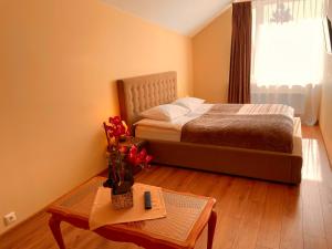 包斯卡SPA&Hotel MŪSA PARADISE的一间卧室配有一张床和一张鲜花桌子