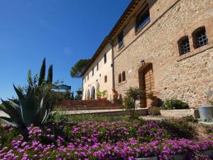 Castello delle FormeSCAPPO IN UMBRIA, Casale的一座在前面布满紫色花的建筑