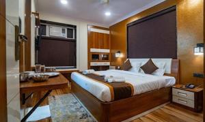 加尔各答FabHotel Prime Tiyara Inn的一间卧室配有一张带书桌和水槽的床。