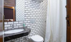 加尔各答FabHotel Prime Tiyara Inn的一间带水槽、卫生间和镜子的浴室