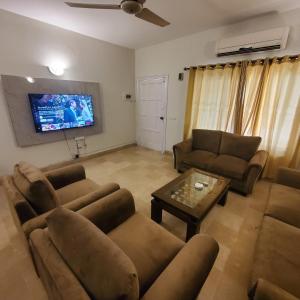 伊斯兰堡Private Suite F-10 Islamabad的带沙发和平面电视的客厅