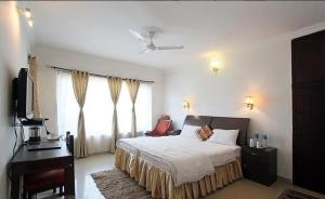 PadmiVan Durga Villas & Suites的一间卧室配有一张床、一张书桌和一台电视