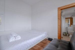 伦敦Bright & Quaint Studio Flat - Hornsey!的白色卧室配有床和沙发
