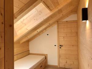 巴迪亚玛丽亚公寓式酒店的小型阁楼间设有床和木制天花板