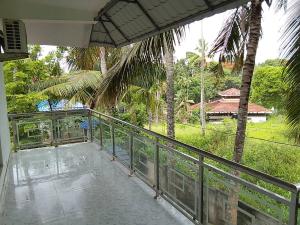 可瓦兰Somatheertham Panchakarma Resort的享有房屋景致的阳台