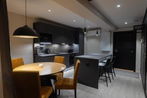 罗瓦涅米Royal Roi Apartments的厨房以及带木桌和椅子的用餐室。
