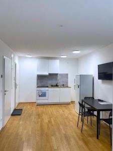 维也纳Vienna´s Danube Apartments的客房设有厨房、桌子和椅子。