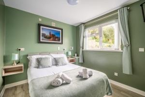 伦敦德里张伯伦之家酒店的绿色卧室配有一张大床和毛巾
