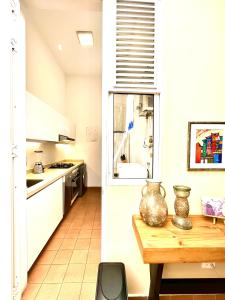 卡利Casa Rambla Serra Cali的厨房配有白色橱柜和木桌