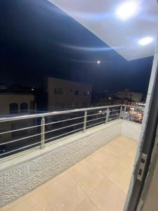 马达巴King mesha luxury apartment original的阳台,晚上可欣赏到城市景观