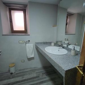 坎加斯德尔纳尔塞亚Habitaciones Pumarada 2的一间带水槽和镜子的浴室以及窗户。