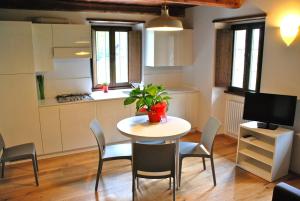 CadareseIl Borgo Antico的一间带桌椅的厨房和一间带桌子及植物的厨房