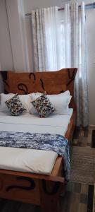 NarokSajaairbnb的一间卧室配有一张带木制床头板和枕头的床。