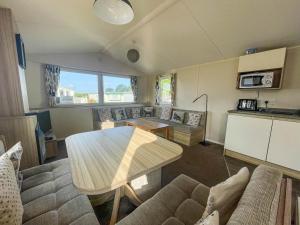 大雅茅斯Superb 6 Berth, Dog Friendly Caravan For Hire By The Beach In Norfolk Ref 50008m的客厅配有桌子和沙发