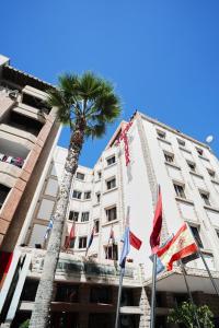 拉巴特泰素达酒店的一座带旗帜的建筑前的棕榈树