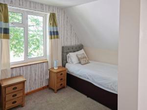 甘尼斯莱克Dartmoor 3的一间小卧室,配有床和窗户