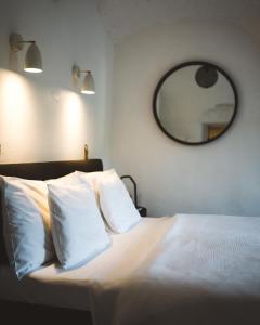 捷克克鲁姆洛夫Domeček / Tiny House的一间卧室配有一张带白色枕头和镜子的床