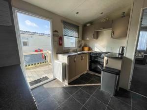 大雅茅斯Superb 8 Berth Caravan For Hire At A Great Holiday Park In Norfolk Ref 50026m的厨房配有水槽和炉灶