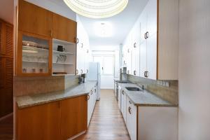 特拉维夫Charming 2BR by HolyGuest的一间大厨房,配有白色的橱柜和水槽