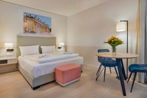 波茨坦Elisapart - Apartments am Sommerschloss的酒店客房配有一张床铺和一张桌子。