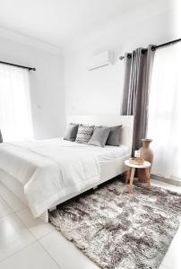 莱基Lekki FootPrint, Lekki Phase1的白色卧室配有大床和地毯
