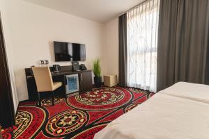 普图伊Casino & Hotel ADMIRAL Ptuj的配有一张床和一台平面电视的酒店客房