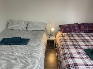 伦敦Great 5-Bed Wembley Home 25min from Central London的卧室内两张并排的床