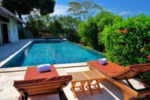贝岛ANJARA LODGE Villa de 3 chambres的一个带两把椅子和一张桌子的游泳池