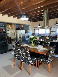 兰舒凯马杜Quinta da Serra - Onde o charme se mistura com a natureza的厨房配有木桌和黑白椅子
