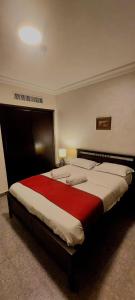 安曼Tamrah Suites Hotel的一间卧室配有一张带红色毯子的大床