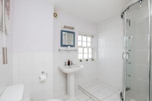 亨利昂泰晤士Olive Tale的白色的浴室设有水槽和淋浴。